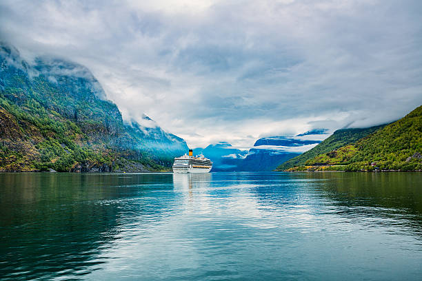 Cruise ship sailing through a fjord with mountains